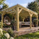A large wooden pergola with a clear roof over a raised patio deck, furnished with a beige outdoor sofa, coffee table, hanging wicker egg chair, and potted plants, set in a landscaped garden.