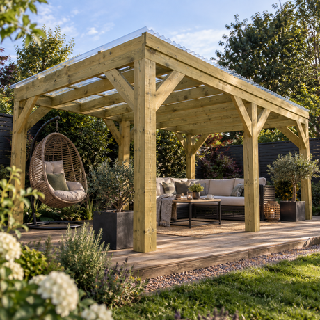 A large wooden pergola with a clear roof over a raised patio deck, furnished with a beige outdoor sofa, coffee table, hanging wicker egg chair, and potted plants, set in a landscaped garden.